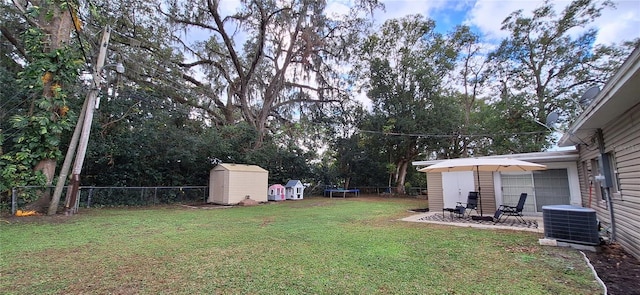 view of yard featuring a storage shed, a patio, central AC unit, and a trampoline