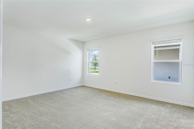 carpeted spare room featuring baseboards and recessed lighting