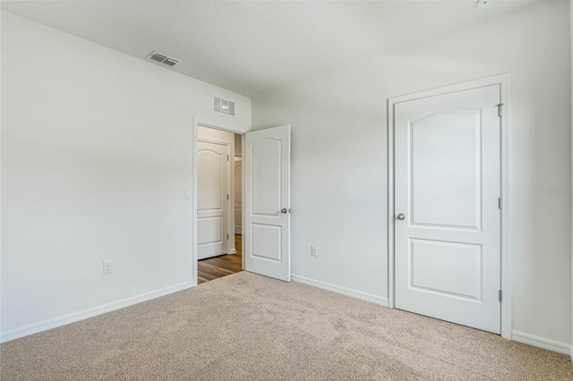 unfurnished bedroom featuring carpet, visible vents, and baseboards