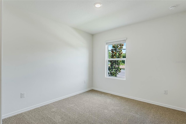 carpeted spare room with baseboards