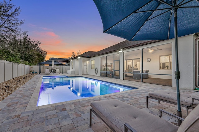 pool at dusk with a patio