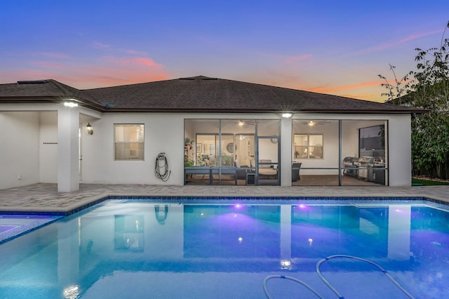 pool at dusk featuring a patio area