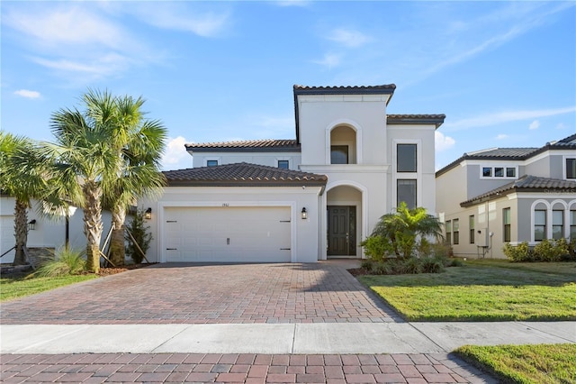 mediterranean / spanish house featuring a garage and a front yard