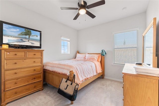 bedroom featuring multiple windows, ceiling fan, and light carpet