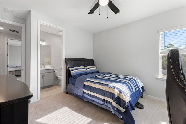 carpeted bedroom with ceiling fan and ensuite bathroom