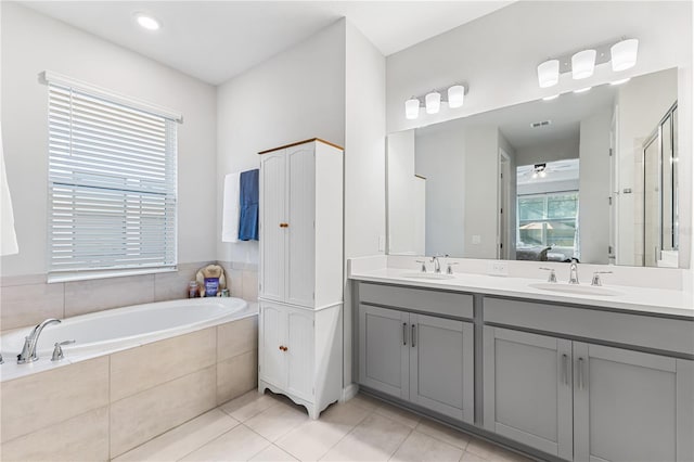 bathroom with a wealth of natural light, tile patterned flooring, vanity, and shower with separate bathtub