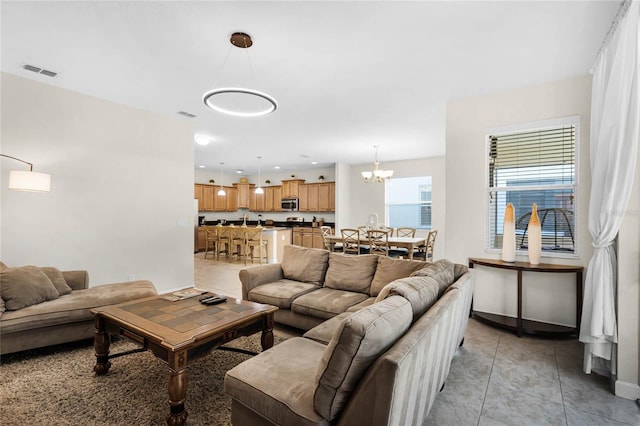 living room featuring light tile patterned floors and an inviting chandelier