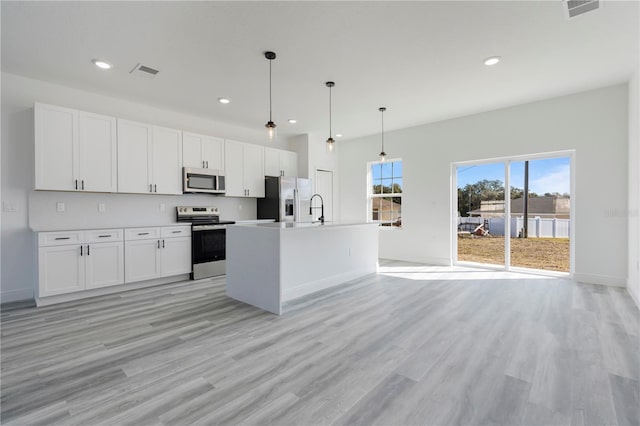 kitchen featuring white cabinetry, an island with sink, pendant lighting, and appliances with stainless steel finishes