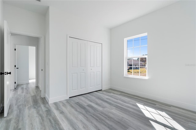 unfurnished bedroom with a closet and light hardwood / wood-style floors