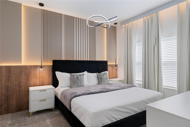 carpeted bedroom featuring wooden walls