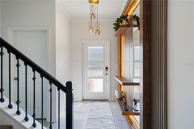 foyer with light tile patterned floors, crown molding, and a notable chandelier