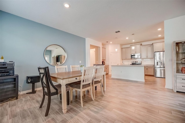 dining space with light hardwood / wood-style flooring