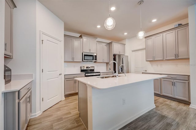 kitchen with pendant lighting, sink, gray cabinetry, and stainless steel appliances