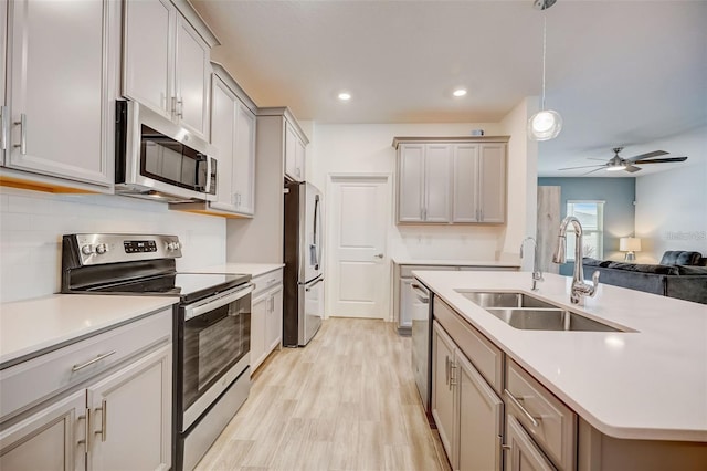 kitchen featuring sink, hanging light fixtures, ceiling fan, gray cabinets, and stainless steel appliances