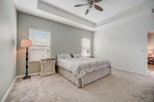 bedroom featuring carpet, ceiling fan, and a tray ceiling