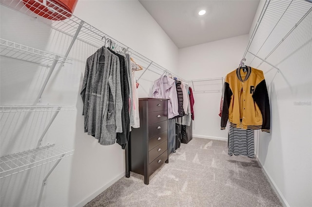 walk in closet with light carpet