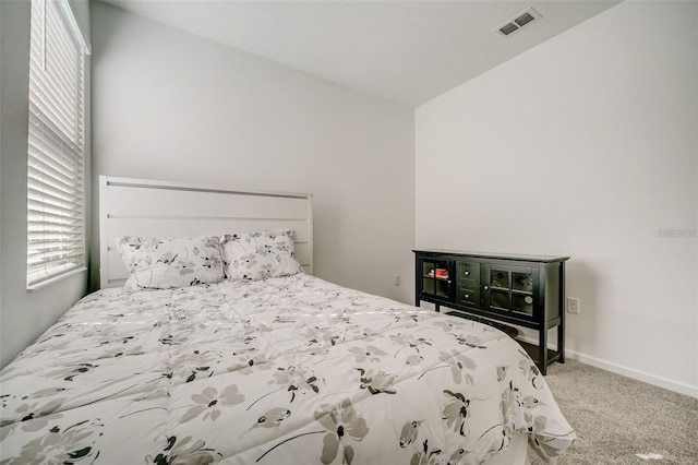 bedroom with carpet, multiple windows, and lofted ceiling