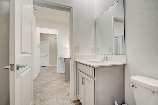 bathroom with vanity, hardwood / wood-style flooring, and toilet