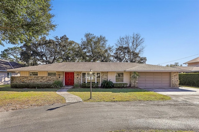 ranch-style house featuring a garage and a front yard