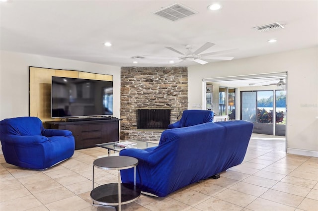 living room featuring a stone fireplace and light tile patterned flooring