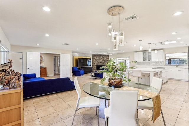 tiled dining space featuring a fireplace and sink