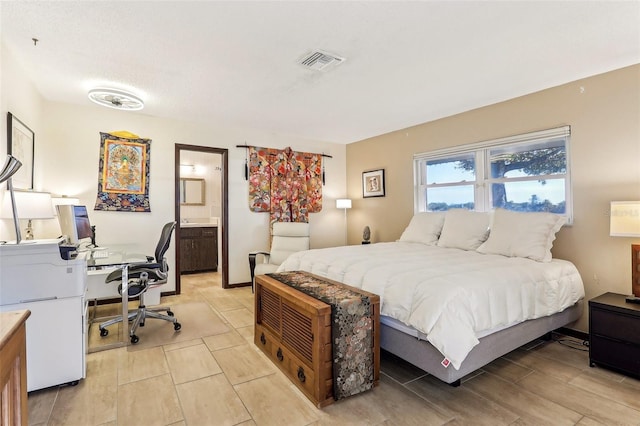 bedroom featuring connected bathroom and refrigerator