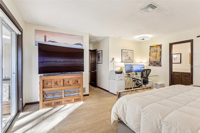 bedroom with ensuite bathroom and a textured ceiling