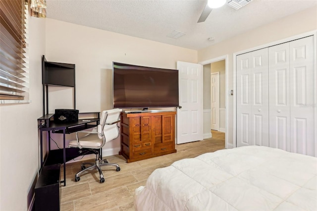 bedroom with ceiling fan, a closet, and a textured ceiling