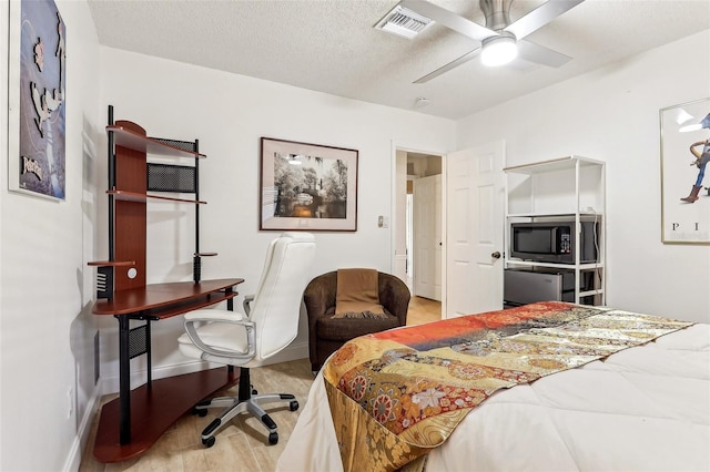 bedroom featuring light wood-type flooring, a textured ceiling, and ceiling fan