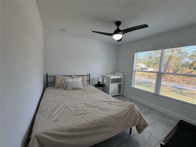 bedroom with ceiling fan and light tile patterned floors