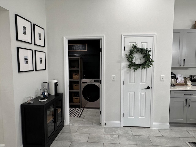 interior space with light tile patterned floors and washer / clothes dryer