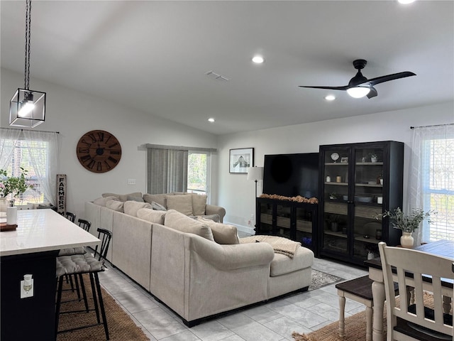 living room with lofted ceiling, light tile patterned floors, ceiling fan, and a wealth of natural light