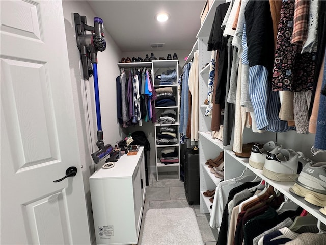 walk in closet featuring light tile patterned floors and washing machine and dryer