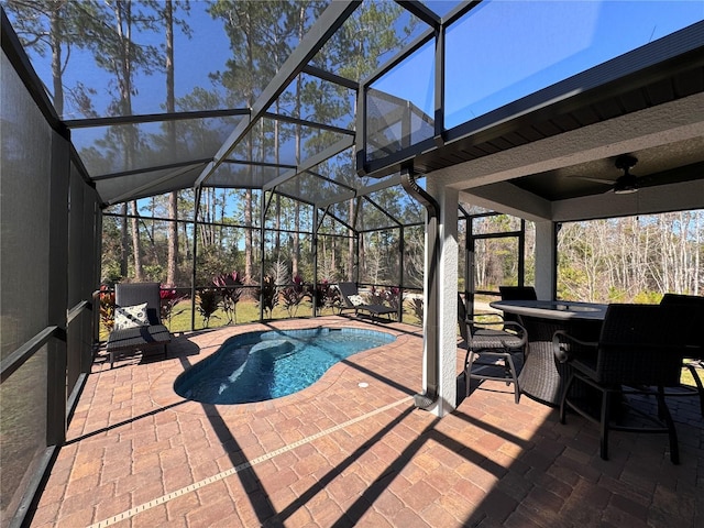 view of pool featuring ceiling fan, a lanai, a bar, and a patio