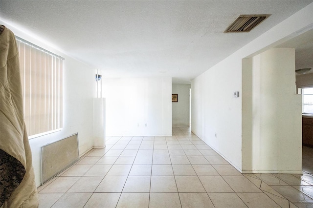 empty room featuring light tile patterned floors and a textured ceiling