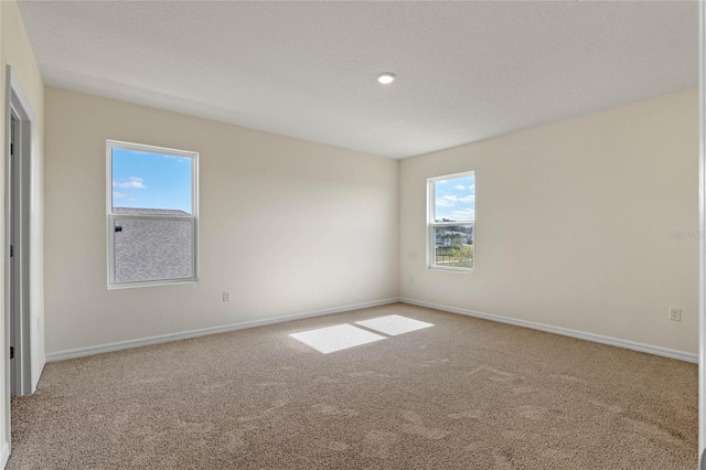 carpeted spare room featuring a textured ceiling