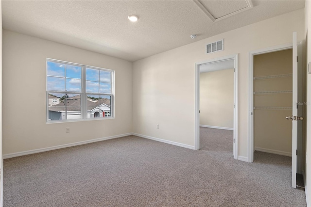 carpeted empty room with a textured ceiling