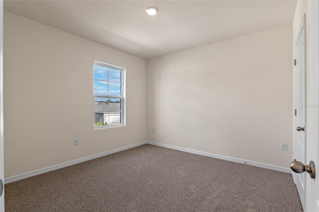 empty room with carpet floors and a textured ceiling