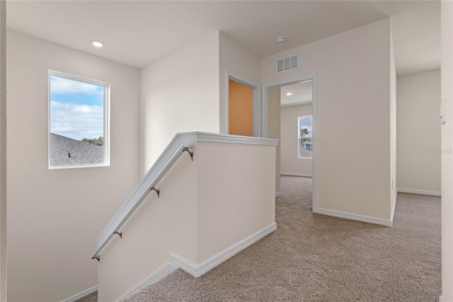 corridor featuring light colored carpet