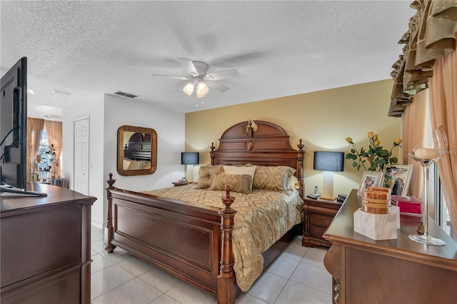 tiled bedroom with ceiling fan, a closet, and a textured ceiling