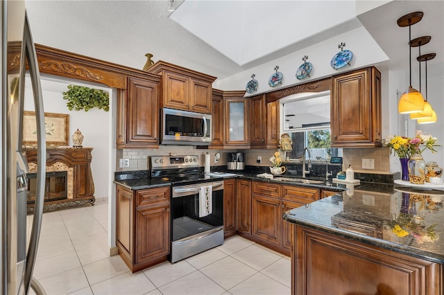 kitchen with pendant lighting, decorative backsplash, light tile patterned flooring, and stainless steel appliances