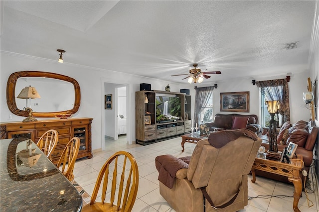 living room featuring ceiling fan, light tile patterned flooring, and a textured ceiling