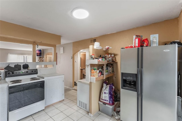 kitchen with light tile patterned floors, stainless steel fridge, refrigerator, and white electric range