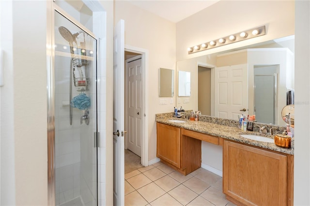 bathroom with tile patterned floors, vanity, and a shower with door