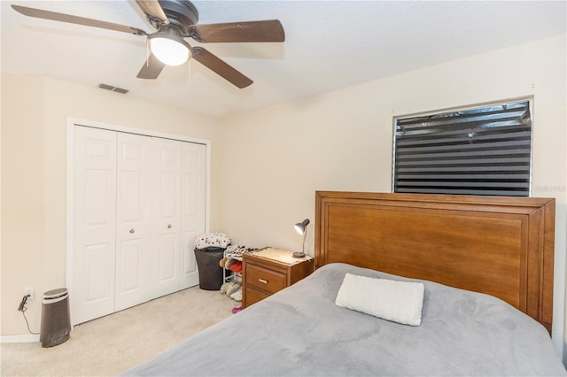 carpeted bedroom featuring ceiling fan and a closet