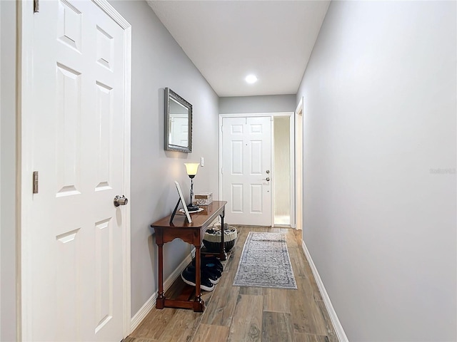 doorway to outside with baseboards and wood finished floors