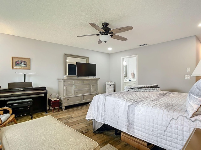 bedroom with visible vents, ceiling fan, a textured ceiling, and wood finished floors