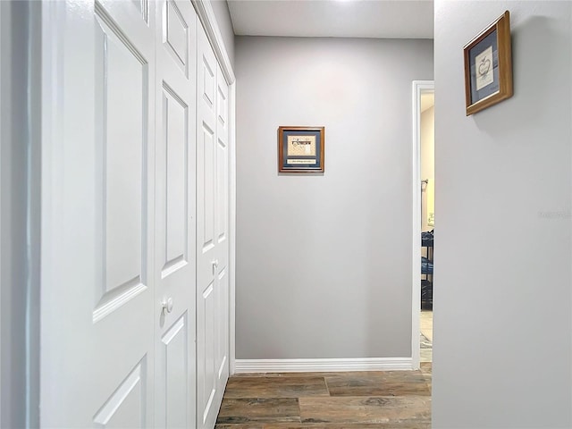 hallway with dark wood-type flooring and baseboards