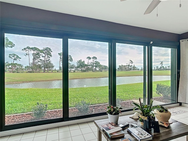 sunroom featuring a water view and ceiling fan