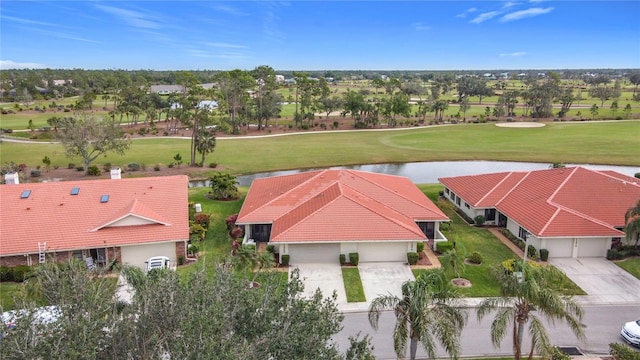 drone / aerial view with a water view and view of golf course